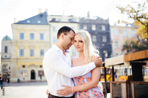 Young couple in love hug each other on city background
