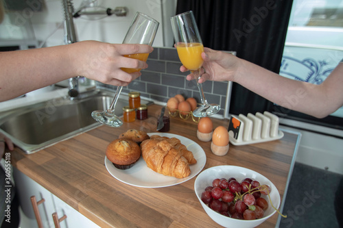 A celebration breakfast is served in this trendy renovated camper van, includes eggs, croissants, orange juice etc served on wooden kitchen surface and grey tiled kitchen area