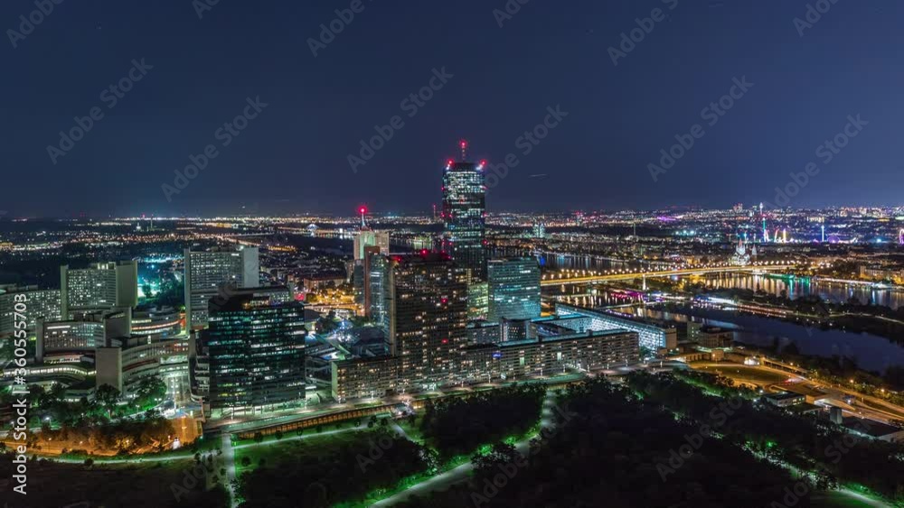 Aerial panoramic view over Vienna city with Donau City skyscrapers, historic buildings and a riverside promenade night timelapse in Austria. Illuminated skyline from Danube Tower viewpoint Aerial panoramic view over Vienna city with Donau City skyscrapers, historic buildings and a riverside promenade night timelapse in Austria. Illuminated skyline from Danube Tower viewpoint