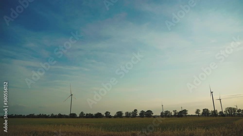 Sunset above the windmills on the field ,agriculture field generator power. Wind power technology - turbine, energy production - green technology, a clean and renewable energy solution,electricity. photo