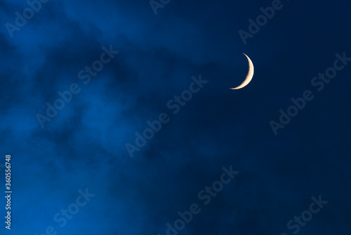 Leinwand Poster Blue foggy sky with crescent or half moon
