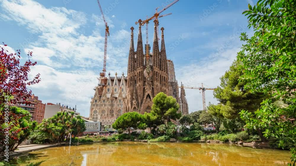 Zoom in tmelapse view of architectural landmark Sagrada Familia Basilica, a large Roman Catholic church in Barcelona, Catalonia, Spain. Beautiful summer day, spires and cranes against blue sky. Zoom in tmelapse view of architectural landmark Sagrada Familia Basilica, a large Roman Catholic church in Barcelona, Catalonia, Spain. Beautiful summer day, spires and cranes against blue sky.