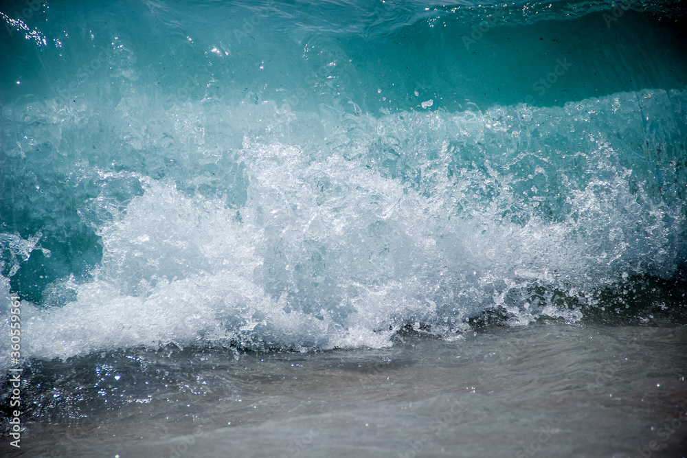 Lagoon blue wave slash over sandy beach Lagoon blue wave slash over sandy beach