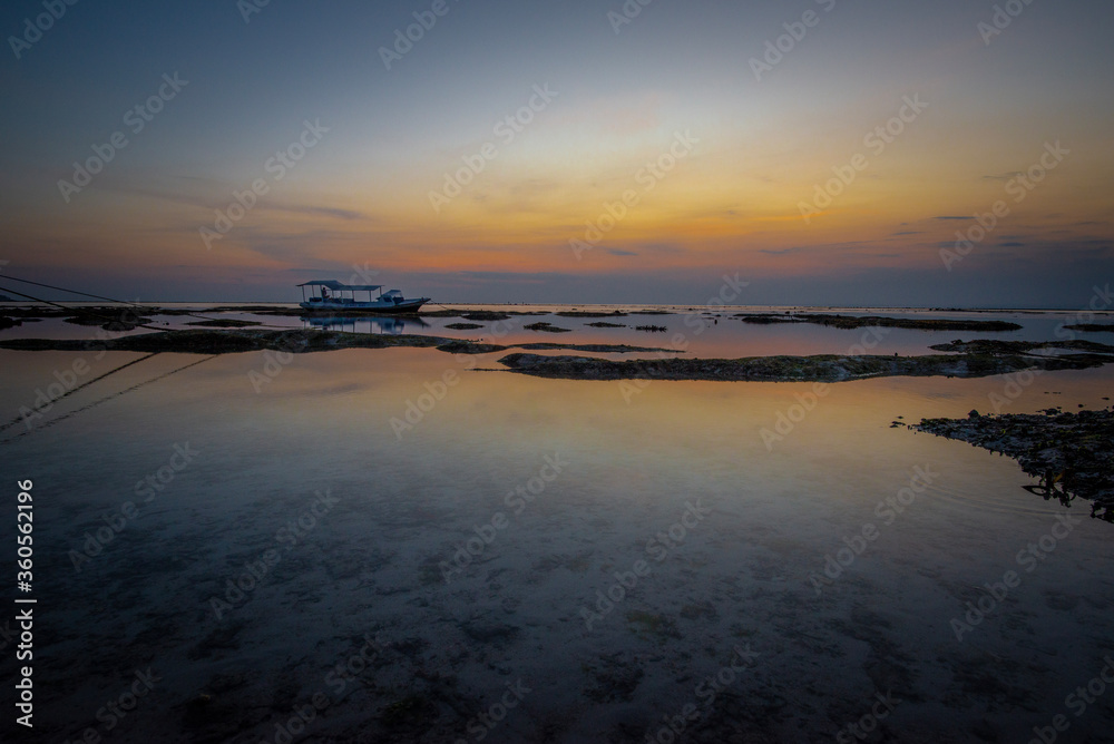 Obraz premium One boat stranded on sand at dusk, Nusa Lembongan, Bali