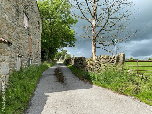 Rural lane, leading over the hills, with heavy clouds above in, Farnhill, Keighley, UK photo