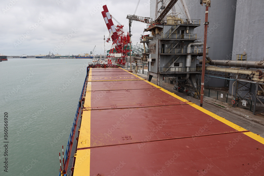 Top view of small general cargo ship berthed at sea port Top view of small general cargo ship berthed at sea port