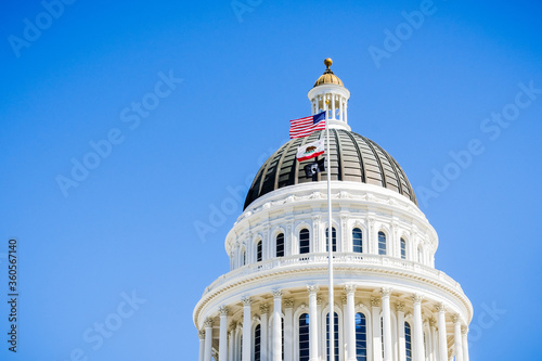 Fotobehang The US and the California state flag waving in the wind in front of the dome of