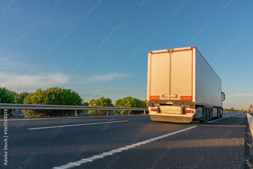 Truck with refrigerated semi-trailer moving on the highway