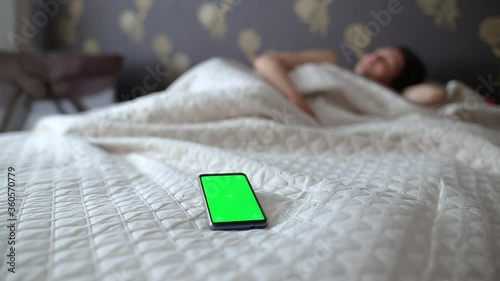 Girl turns off the alarm on the phone with a green screen