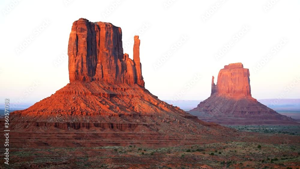 View of famous purple mesa butte formations closeup timelapse with red orange rock color on horizon in Monument Valley canyons during sunset in Arizona