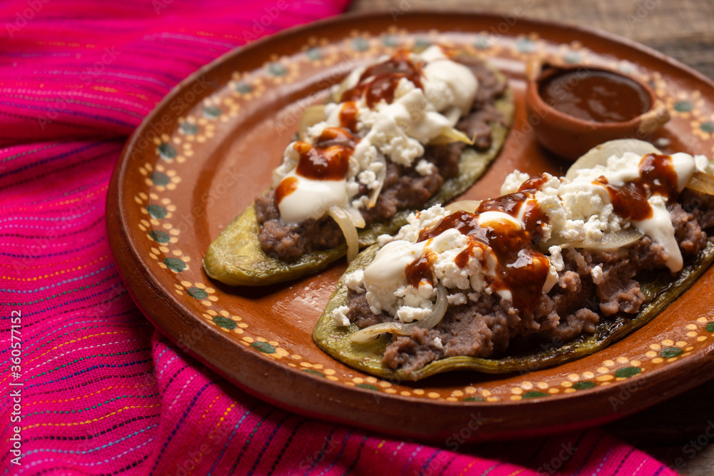 Mexican nopal cactus huaraches with cheese and beans on wooden background Mexican nopal cactus huaraches with cheese and beans on wooden background