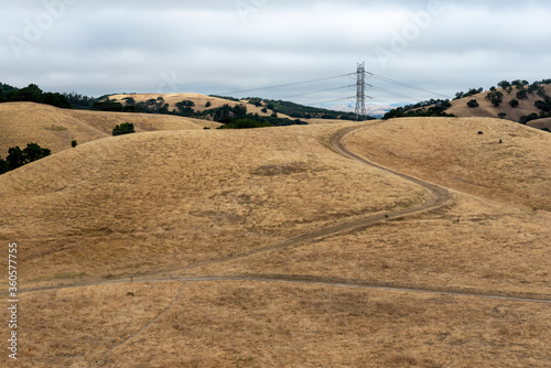 Briones Regional Park hiking trail on a partly cloudy day  featuring dry  brown grass and rolling hills