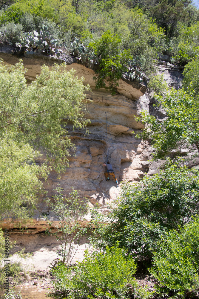a rock climber scaling below a ledge