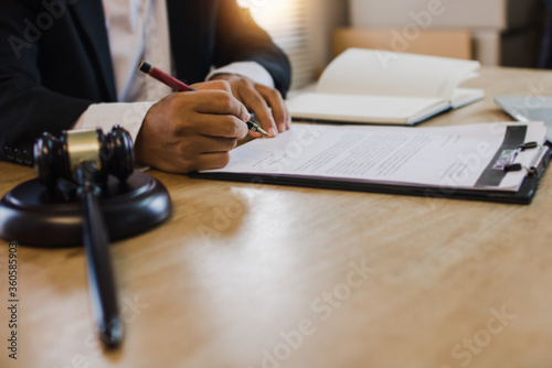hand of business people sign contract with justice hummer on table photo