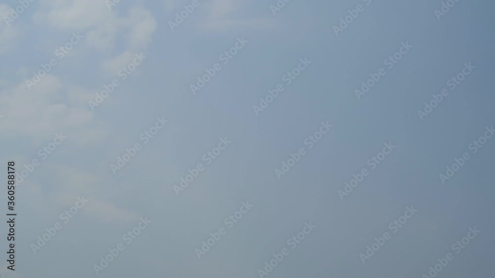 TimeLapse of Sunny wispy blue sky with minimal white cirrus or cirrostratus clouds & fluffy cumulus cloudscap slowly moved on morning sunrise or evening twilight horizon in tropical summer sunlight TimeLapse of Sunny wispy blue sky with minimal white cirrus or cirrostratus clouds & fluffy cumulus cloudscap slowly moved on morning sunrise or evening twilight horizon in tropical summer sunlight