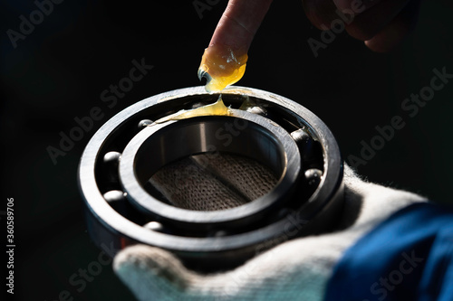 Mechanic is putting yellow grease in the into bearing, engineering and industrial concept.