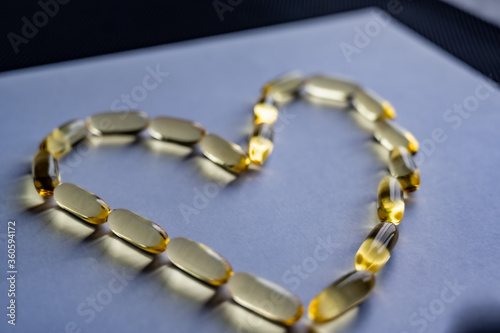 Yellow clear omega-3 gel capsules in the shape of a heart