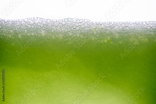 Background of close-up soda bubbles mixed with lemon juice or green juice on white background. photo