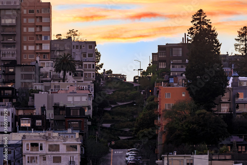 High angle the famous crooked Lombard Street in San Francisco California with a cable car at on the hill at sunset