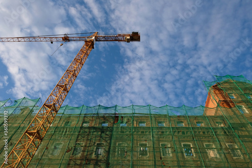 Fotografi restored house and construction crane