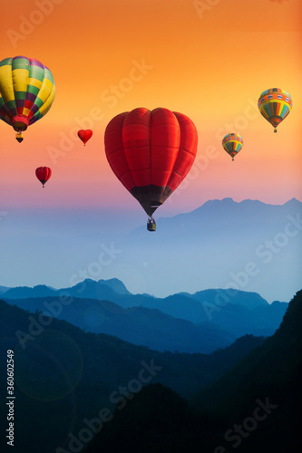 Colorful hot air balloons flying over blue mountains landscape © nutt