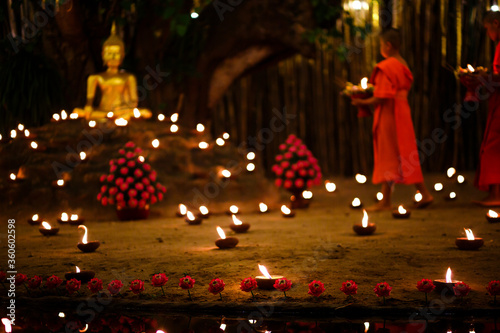 Monks sitting meditate with many candle in Thai temple at night photo