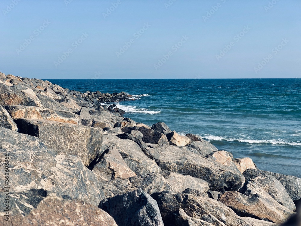 Sea waves on the beach with rocks on the shore at Ennore beach, Tamil nadu