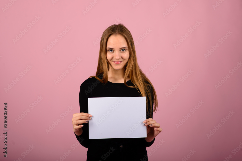Portrait of beautiful young woman with phones and blank signboard. Caucasian blond model posing in studio on pink background. Portrait of beautiful young woman with phones and blank signboard. Caucasian blond model posing in studio on pink background.
