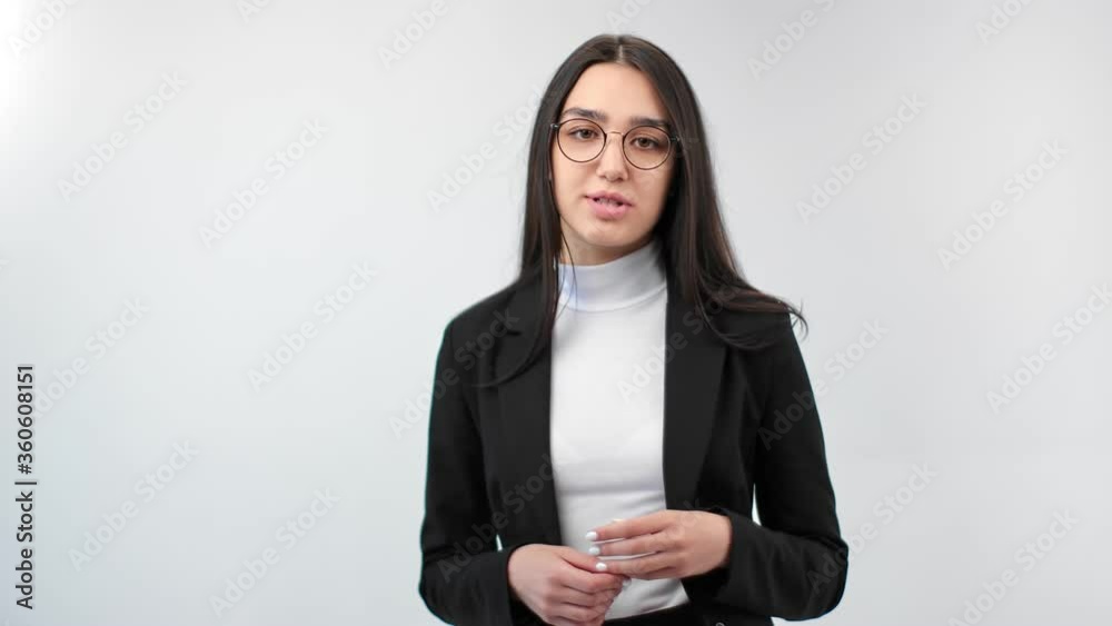 Adorable business woman in glasses talking and explaining isolated. Medium shot on RED camera Adorable business woman in glasses talking and explaining isolated. Medium shot on RED camera