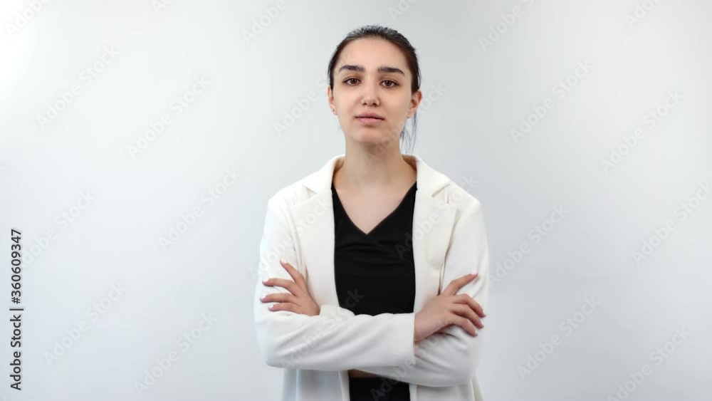 Beautiful stylish young woman posing with crossed hands isolated. Medium shot on RED camera Beautiful stylish young woman posing with crossed hands isolated. Medium shot on RED camera