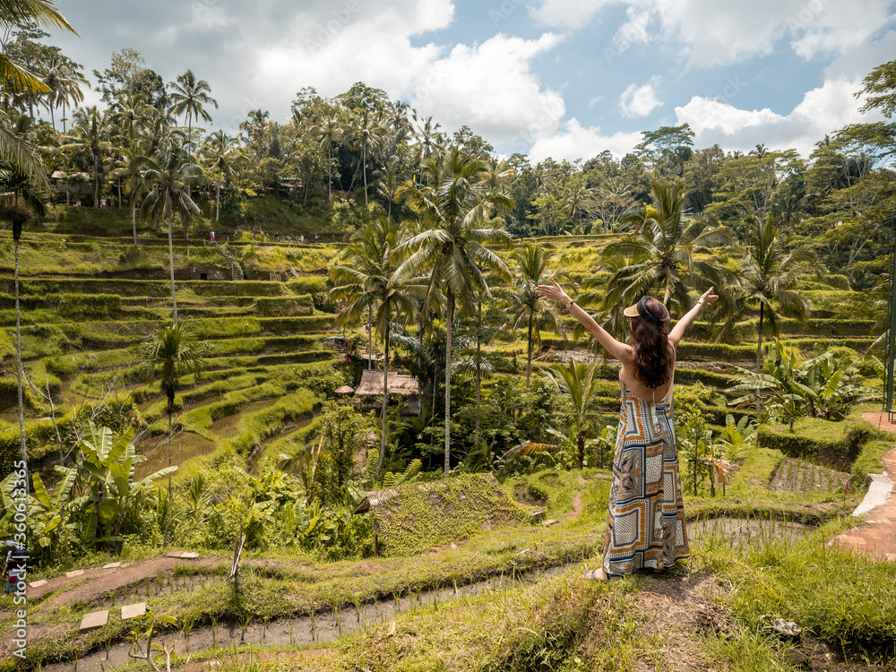 Fototapeta premium Happy woman looking at beautiful tegallalang rice terrace in Bali, Indonesia.
