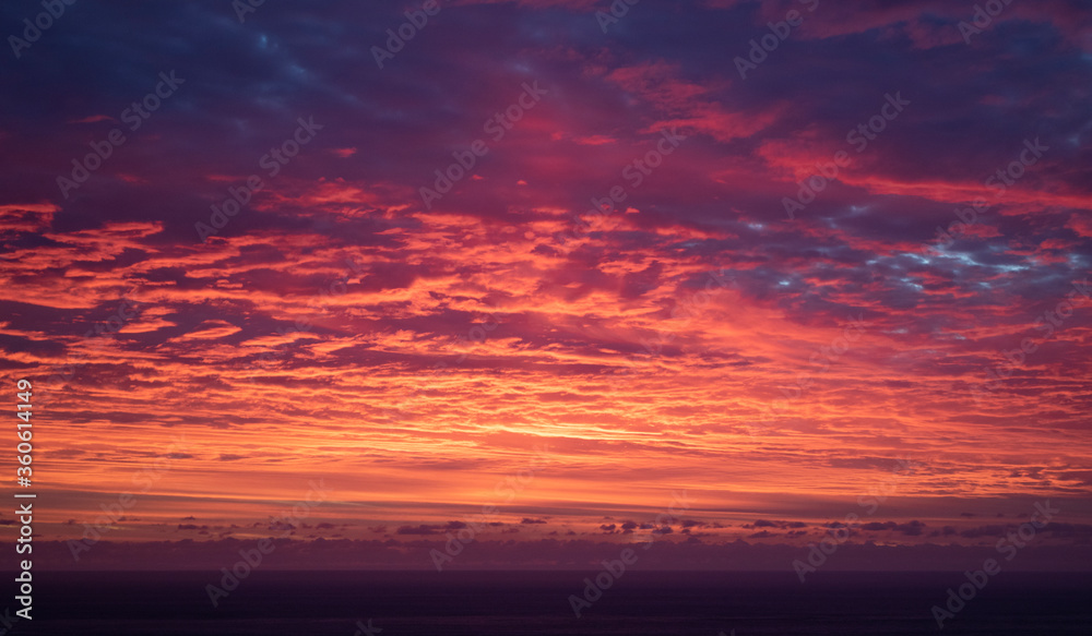 Dramatic firey sunset over the ocean at sunset or sunrise.