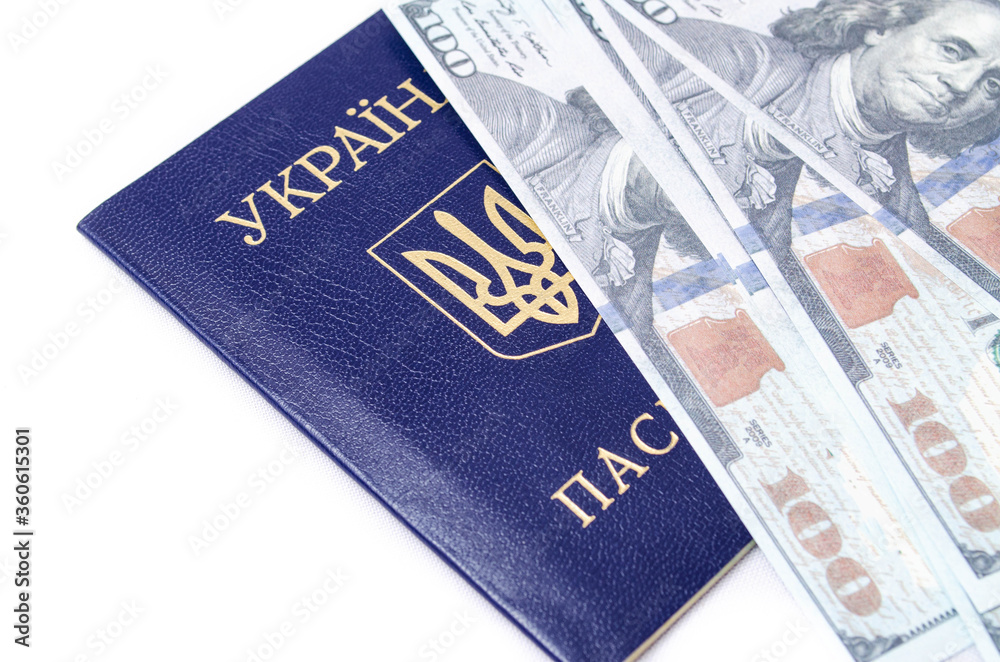 Ukrainian passport on a white background. Dollars with a face value of $ 100 are on the passport at different angles. Ukrainian passport on a white background. Dollars with a face value of $ 100 are on the passport at different angles.