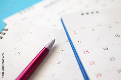 calendar page with pen close up on blue background business planning appointment meeting concept © Piman Khrutmuang