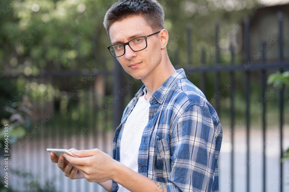 guy in a shirt, with a tablet in his hands on the street guy in a shirt, with a tablet in his hands on the street