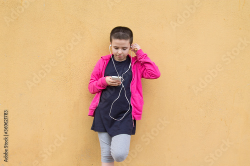 girl with short hair using mobile phone with headphones