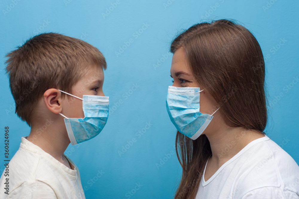 Caucasian mother and son wearing protective medical mask.