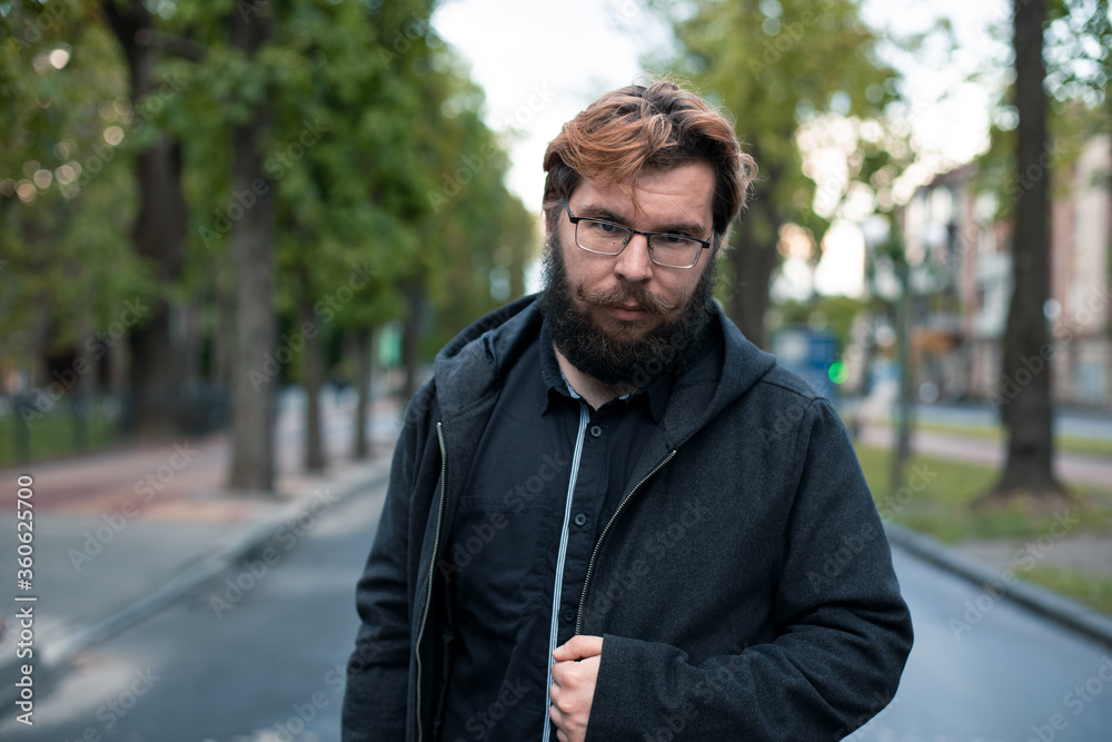 Caucasian man posing on the street middle adult person portrait of bearded person in autumn park outdoor background unfocused environment