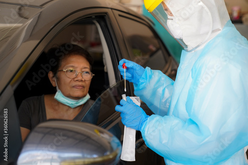The doctors in the PPE protective suit performed a nasal congestion swab covid from a person to test for the coronavirus covid-19 infection.