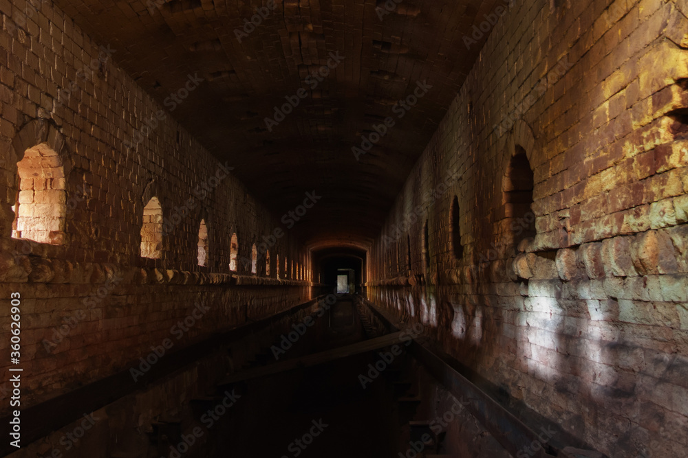 Obraz premium Old ruined brick vaulted tunnel. Dark passage. Underground communication