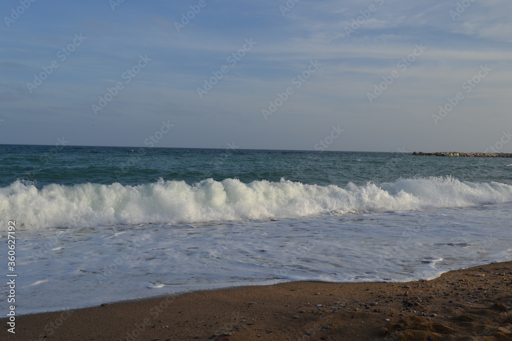 small waves of the Mediterranean Sea roll ashore from pebbles and stones in the afternoon small waves of the Mediterranean Sea roll ashore from pebbles and stones in the afternoon