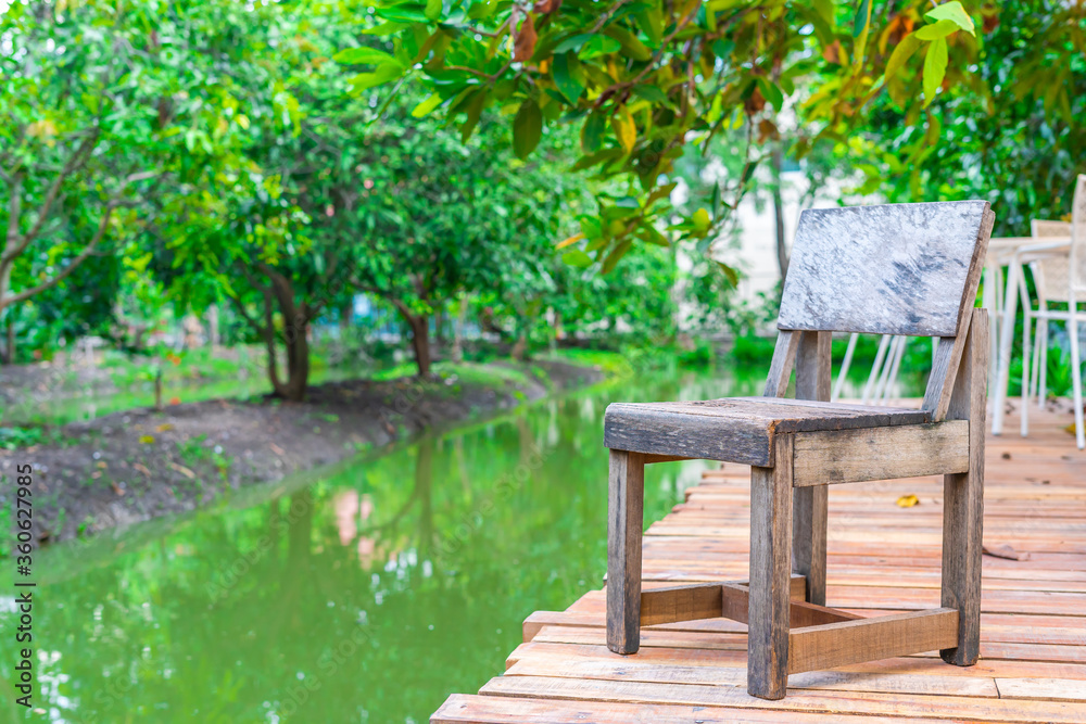 Wooden chairs on the balcony of the orchard with a canal for sitting and resting Wooden chairs on the balcony of the orchard with a canal for sitting and resting
