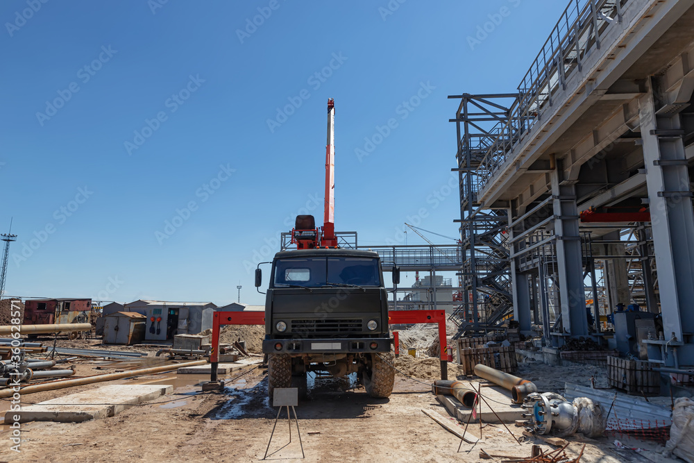 A mobile truck with a lifting boom stands on construction site A mobile truck with a lifting boom stands on construction site