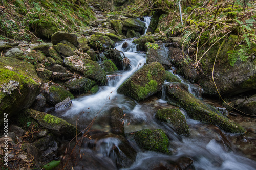 flowing little waterwall with stones and moss