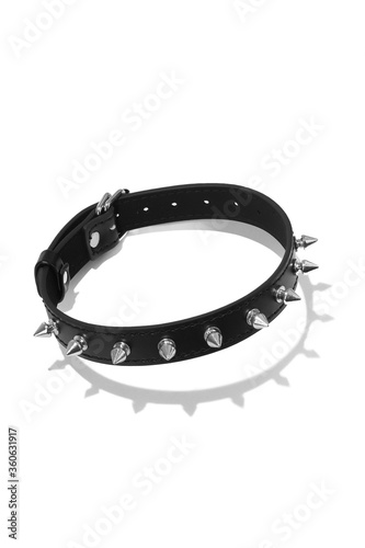 Detailed shot of a black leather collar decorated with spike rivets and steel buckle. The adjustable choker is isolated on the white background.  