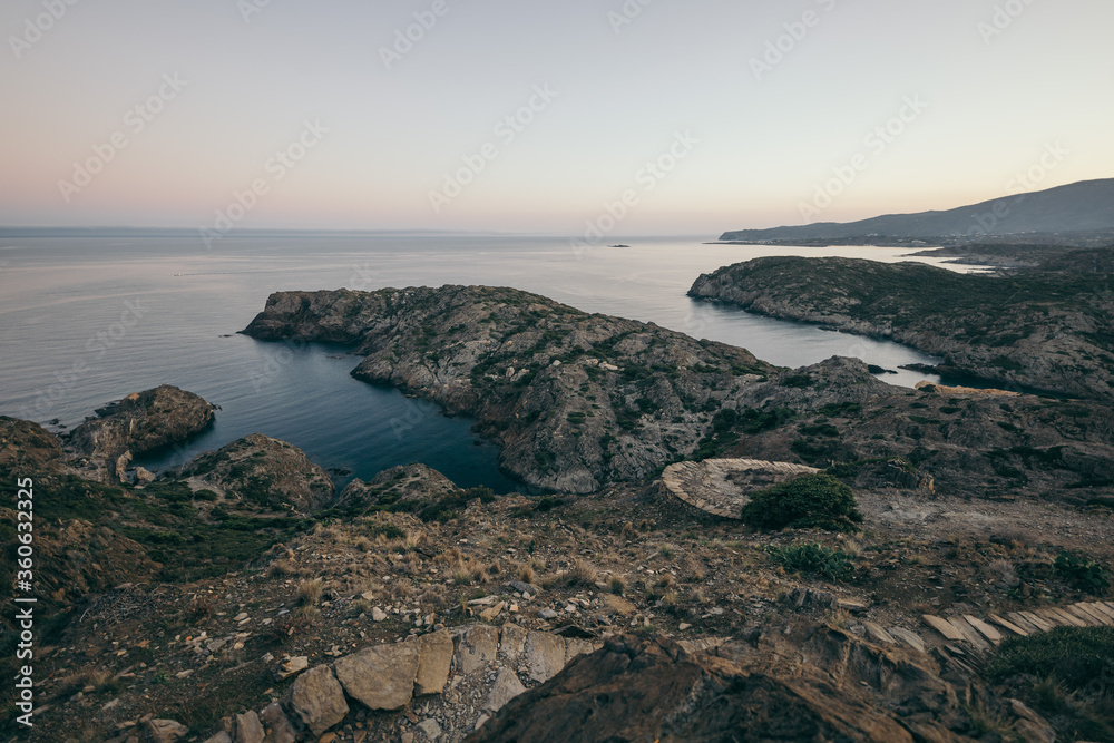 A rocky beach next to a body of water A rocky beach next to a body of water