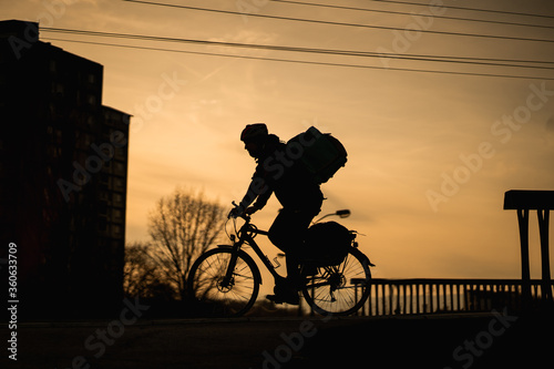 Silhouette of delivery boy on bike