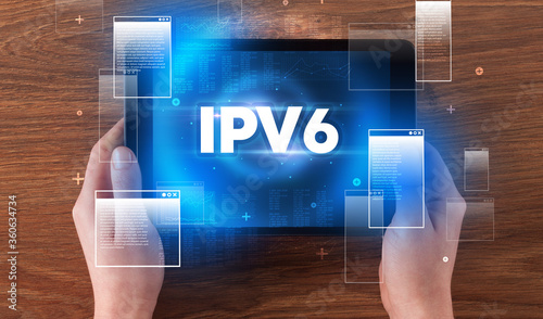 Close-up of a hand holding tablet with IPV6 abbreviation, modern technology concept