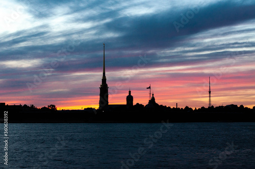Black silhouette of the Peter and Paul Fortress at sunset. White night sky glow in Saint Petersburg, Russia.