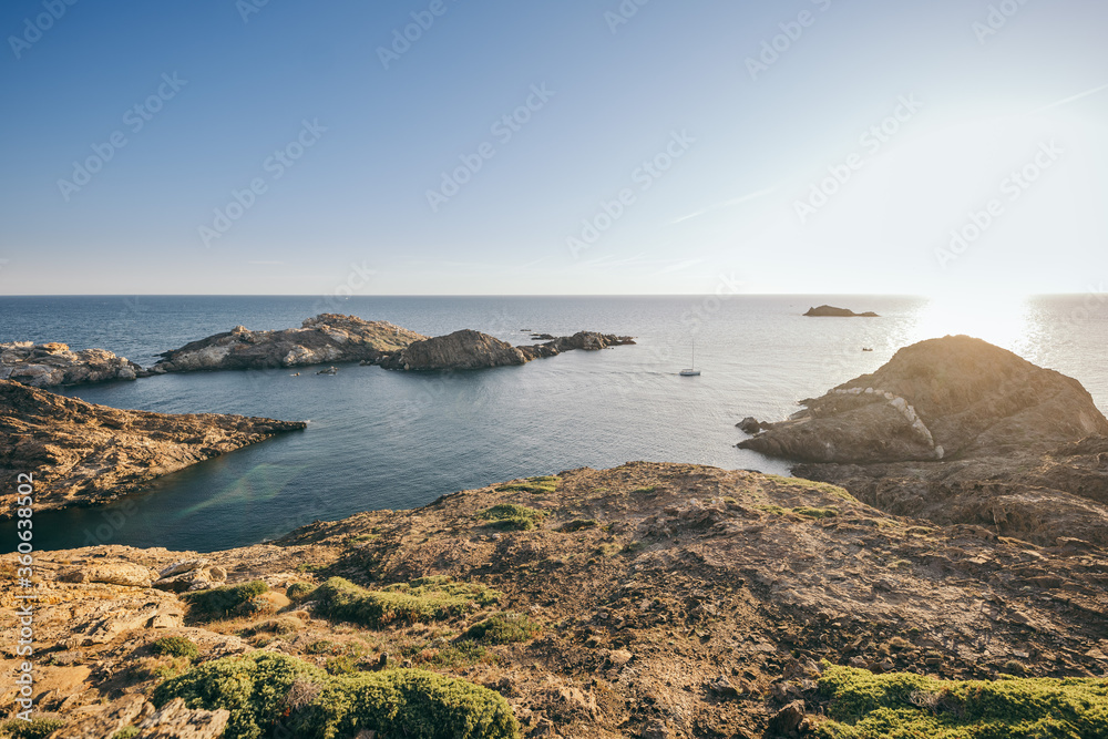 A rocky shore next to a body of water A rocky shore next to a body of water